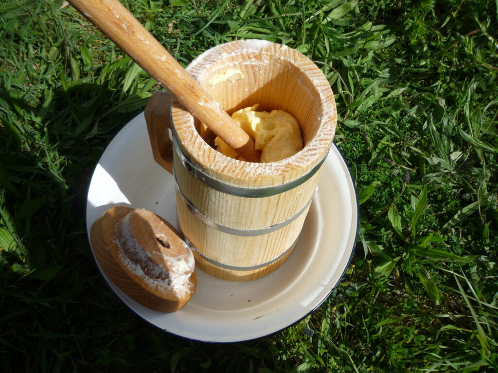 Selbstgemachte Butter im Butterfass aus Holz – traditionelle Lebensmittelverarbeitung ohne elektrische Küchengeräte 